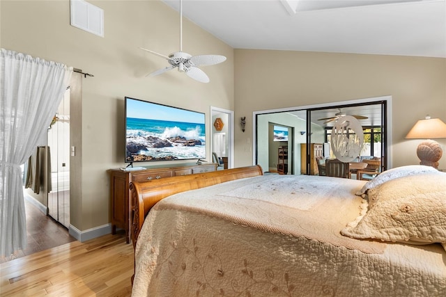 bedroom featuring visible vents, high vaulted ceiling, wood finished floors, baseboards, and ceiling fan