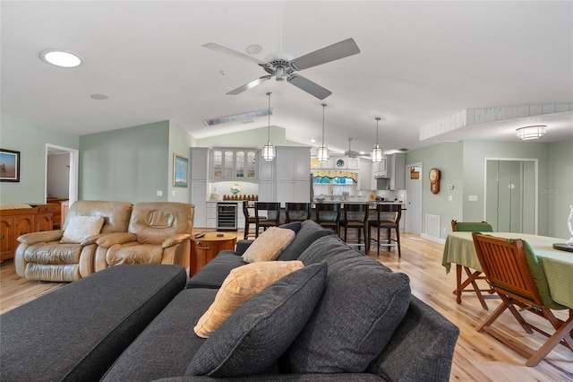 9466 127th Ave, Largo, FL 33773 - living room with light wood finished floors, vaulted ceiling, wine cooler, and a ceiling fan