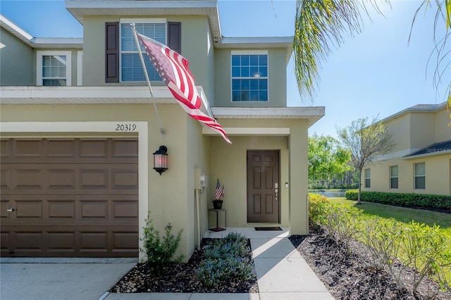 doorway to property with stucco siding and a garage