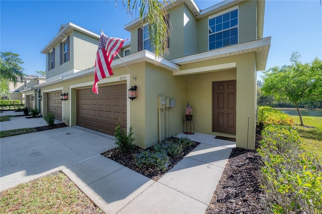 view of front of home featuring an attached garage, driveway, and stucco siding