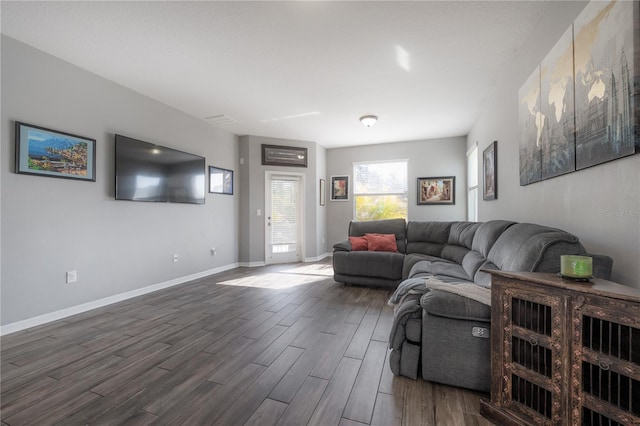 living room with dark wood-type flooring, visible vents, and baseboards