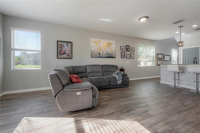 living area with visible vents, baseboards, and dark wood-style flooring