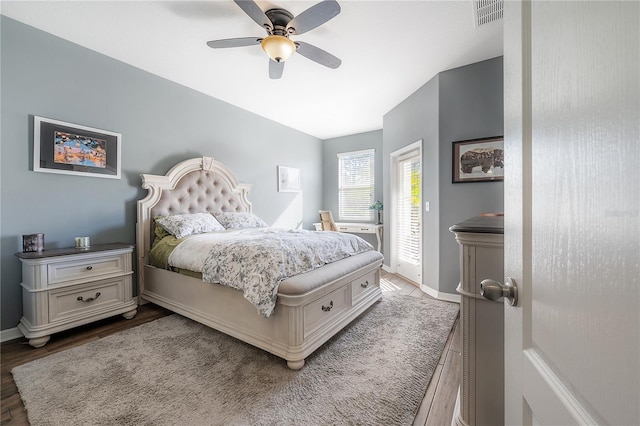 bedroom featuring access to exterior, wood finished floors, visible vents, and baseboards