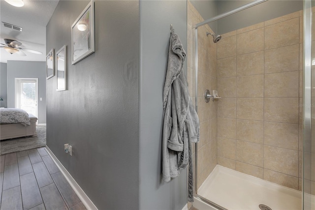 ensuite bathroom featuring a ceiling fan, baseboards, visible vents, a stall shower, and ensuite bathroom