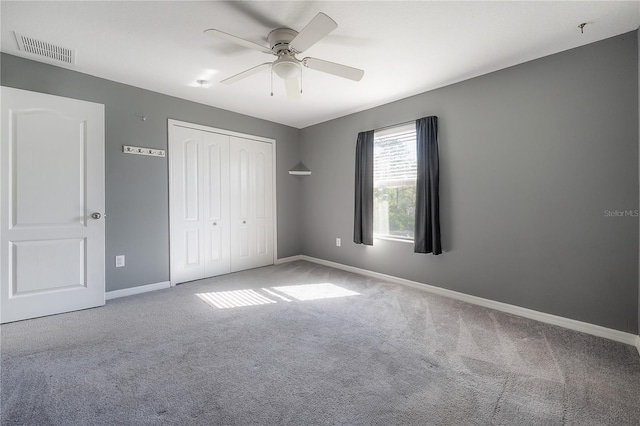 unfurnished bedroom featuring a ceiling fan, baseboards, visible vents, a closet, and carpet flooring