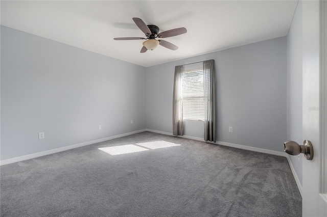 carpeted spare room featuring baseboards and ceiling fan