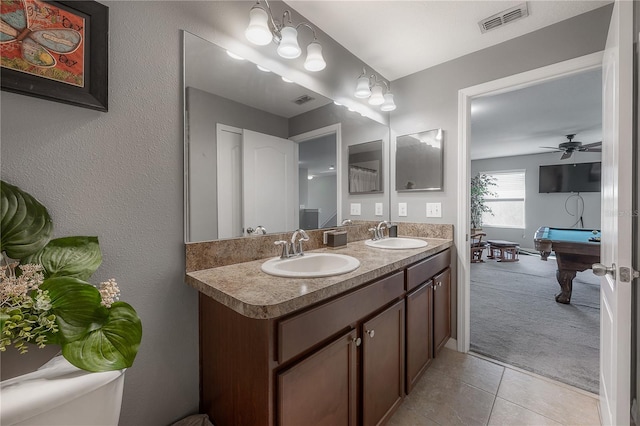 bathroom featuring a sink, visible vents, double vanity, and tile patterned floors