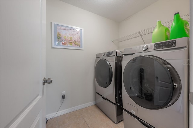 laundry room with laundry area, light tile patterned floors, baseboards, and independent washer and dryer