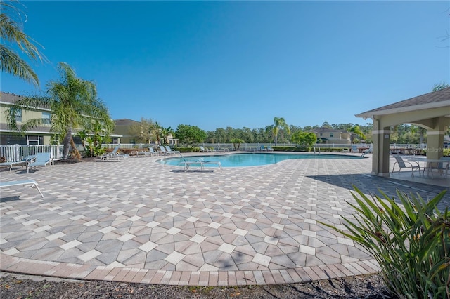 pool with a patio and fence