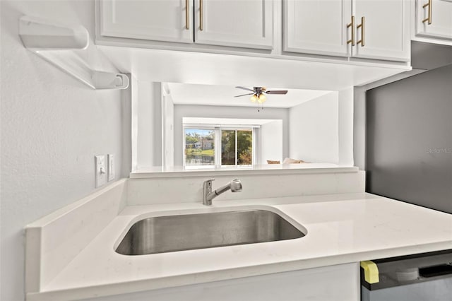 kitchen featuring dishwashing machine, light countertops, a ceiling fan, and a sink