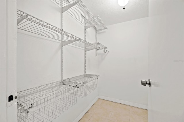 walk in closet with tile patterned floors