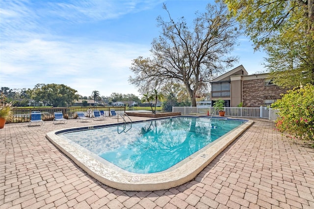 community pool featuring a patio area and fence