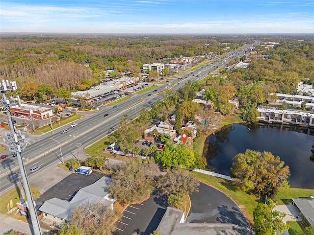 drone / aerial view featuring a water view and a wooded view