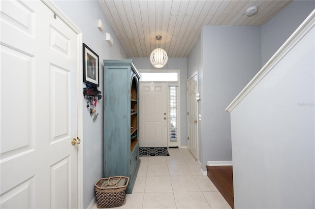 entryway with light tile patterned floors, wooden ceiling, and baseboards