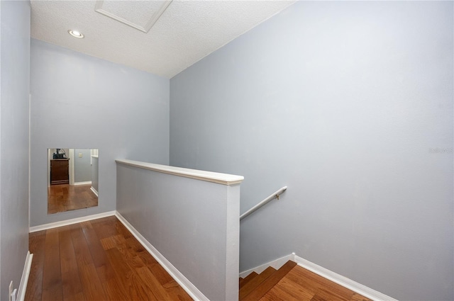 interior space featuring wood finished floors, an upstairs landing, and baseboards