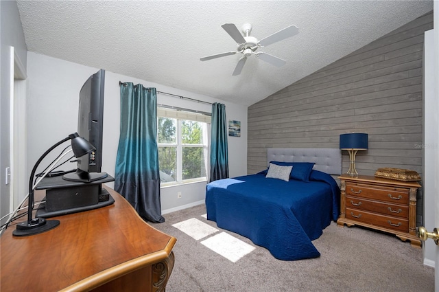 carpeted bedroom with wood walls, a textured ceiling, a ceiling fan, and vaulted ceiling