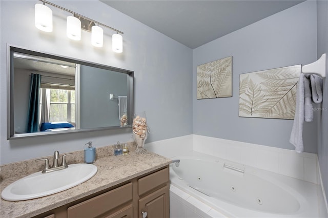 bathroom featuring a tub with jets and vanity