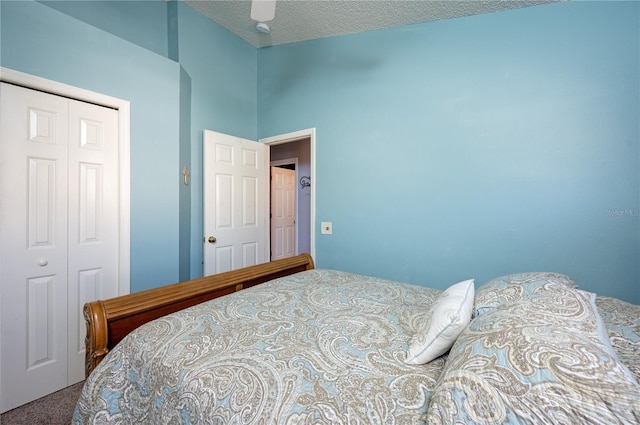 carpeted bedroom with a closet, a textured ceiling, and a ceiling fan