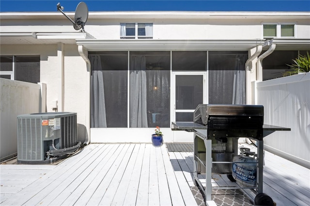 deck featuring cooling unit, fence, visible vents, and a sunroom