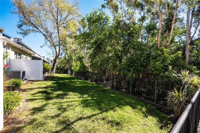 view of yard with central AC unit and fence