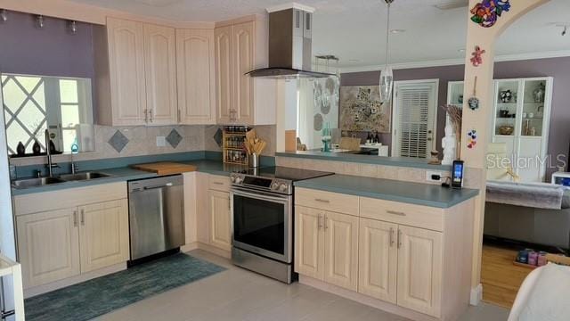 kitchen featuring a sink, stainless steel appliances, crown molding, wall chimney range hood, and backsplash