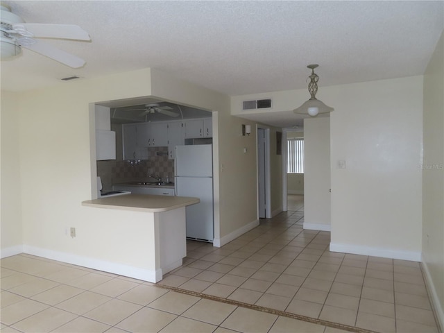 kitchen with a ceiling fan, tasteful backsplash, white appliances, a peninsula, and light tile patterned flooring