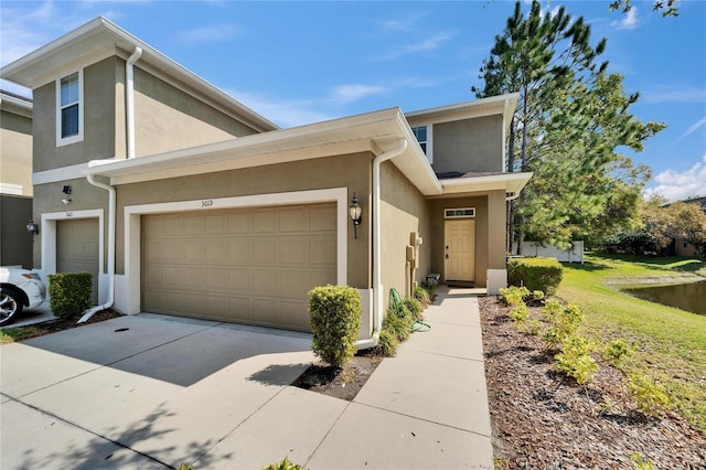 townhome / multi-family property featuring stucco siding, concrete driveway, and a garage