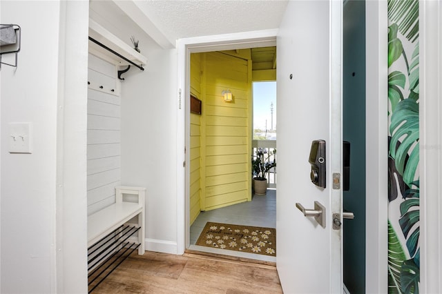 mudroom featuring a textured ceiling and wood finished floors