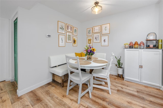 dining area with light wood-type flooring and baseboards