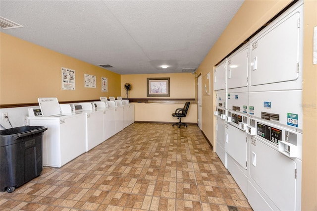 community laundry room with stacked washer / dryer, washing machine and dryer, and visible vents