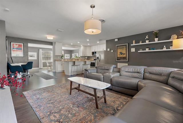 living area featuring dark wood finished floors, visible vents, recessed lighting, and baseboards