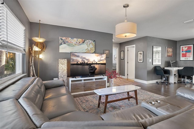 living area with baseboards and wood finished floors