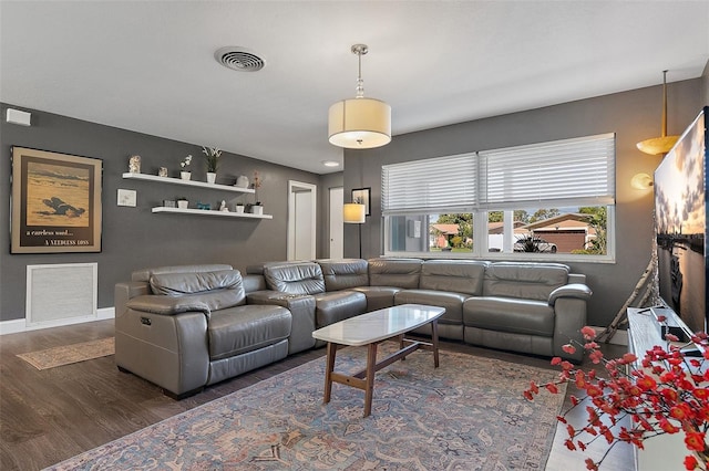 living area featuring wood finished floors, visible vents, and baseboards