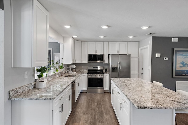 kitchen featuring dark wood finished floors, white cabinetry, visible vents, and appliances with stainless steel finishes