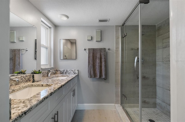 full bathroom with visible vents, a stall shower, and a sink