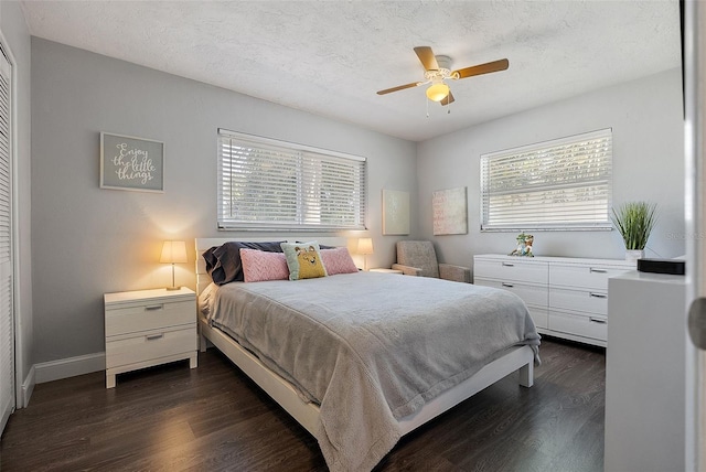 bedroom featuring ceiling fan, baseboards, dark wood-style flooring, and a textured ceiling