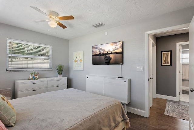 bedroom with visible vents, multiple windows, dark wood-type flooring, and baseboards