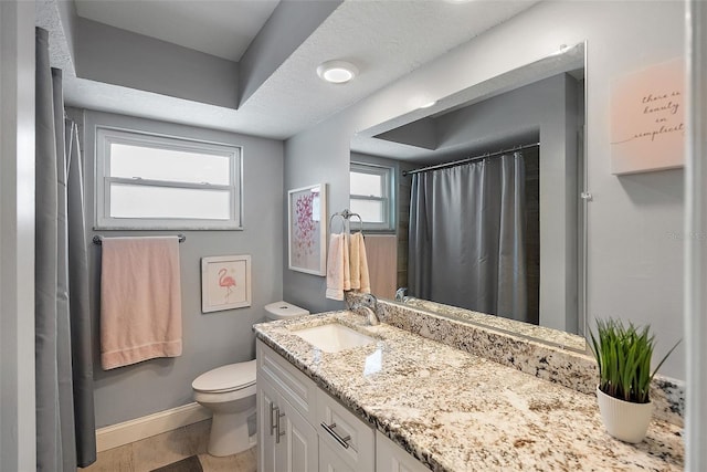 bathroom featuring vanity, toilet, and baseboards