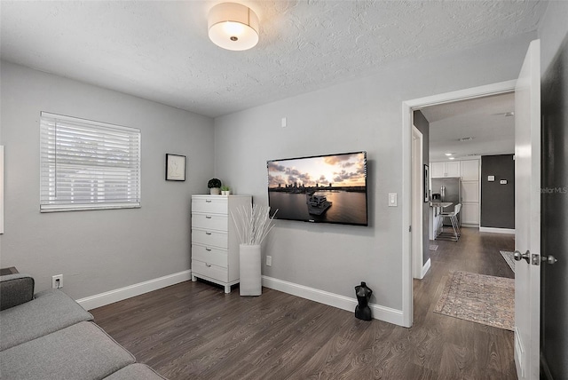 interior space featuring baseboards, a textured ceiling, and dark wood-style floors