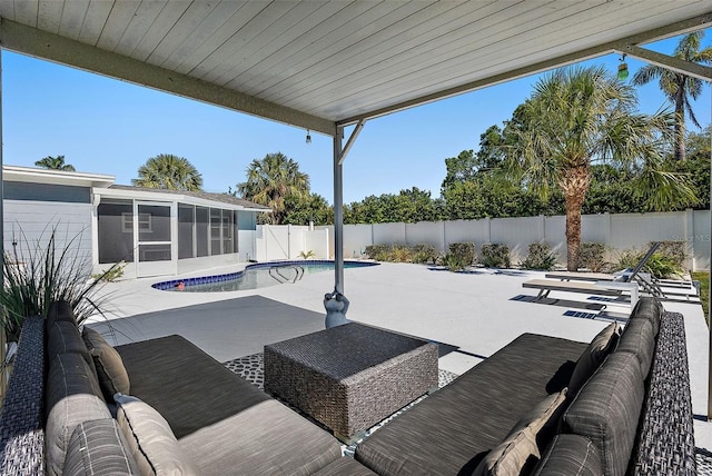 view of swimming pool with an outdoor living space, a fenced in pool, a fenced backyard, a sunroom, and a patio area