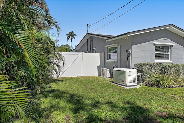 exterior space with ac unit, a yard, fence, and stucco siding