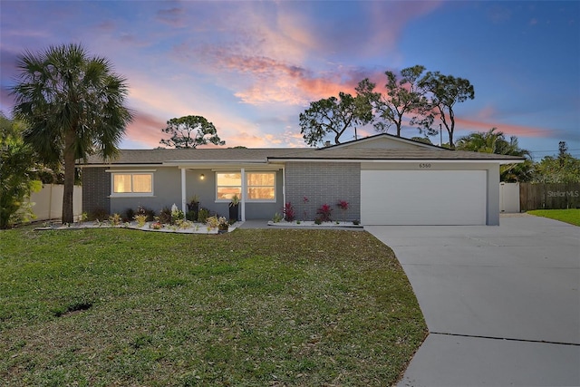 single story home featuring an attached garage, fence, a yard, and driveway