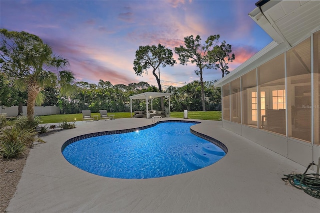 view of swimming pool featuring a patio area, a lawn, a fenced in pool, and a sunroom