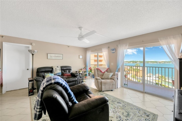 living area with light tile patterned floors, a textured ceiling, and a ceiling fan