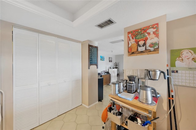 hallway featuring light tile patterned flooring and visible vents