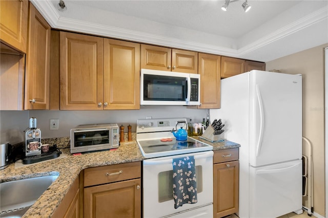 kitchen with light stone counters, a toaster, brown cabinets, and white appliances