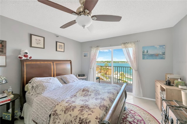 bedroom featuring access to exterior, baseboards, ceiling fan, light tile patterned floors, and a textured ceiling