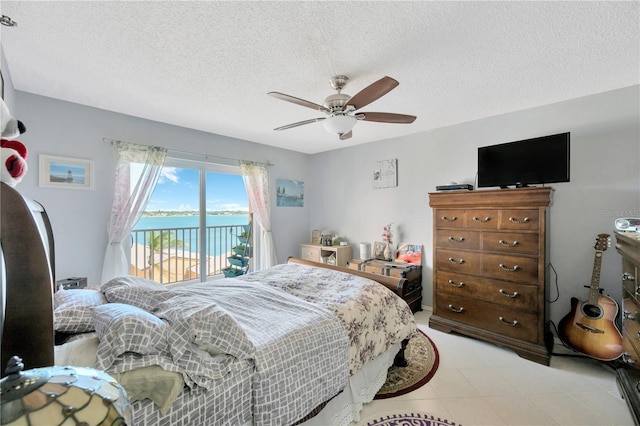 bedroom featuring ceiling fan, access to outside, and a textured ceiling