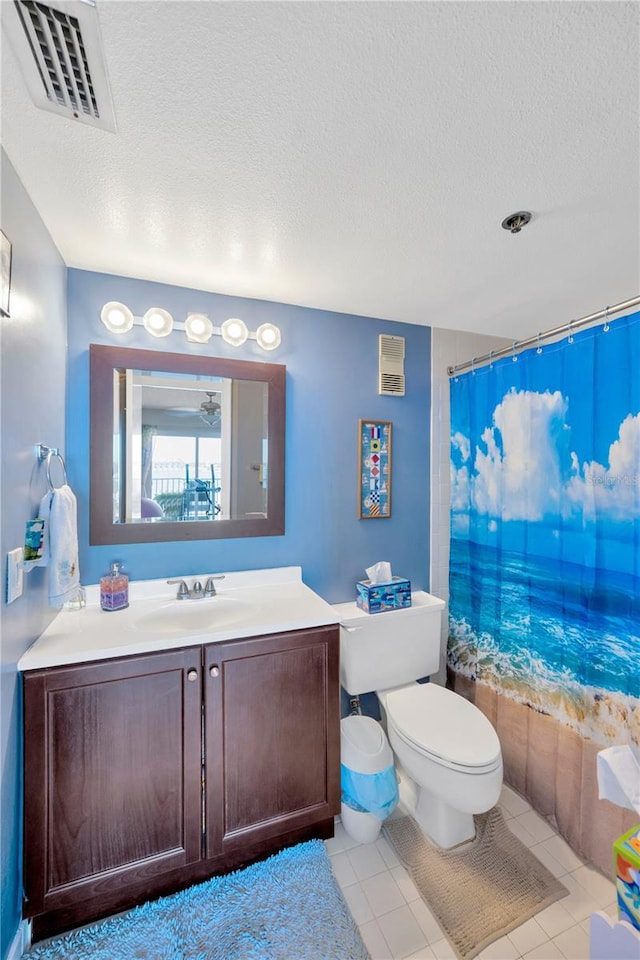 bathroom featuring vanity, toilet, visible vents, and a textured ceiling