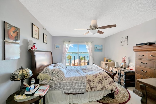 bedroom with a textured ceiling, access to exterior, and a ceiling fan